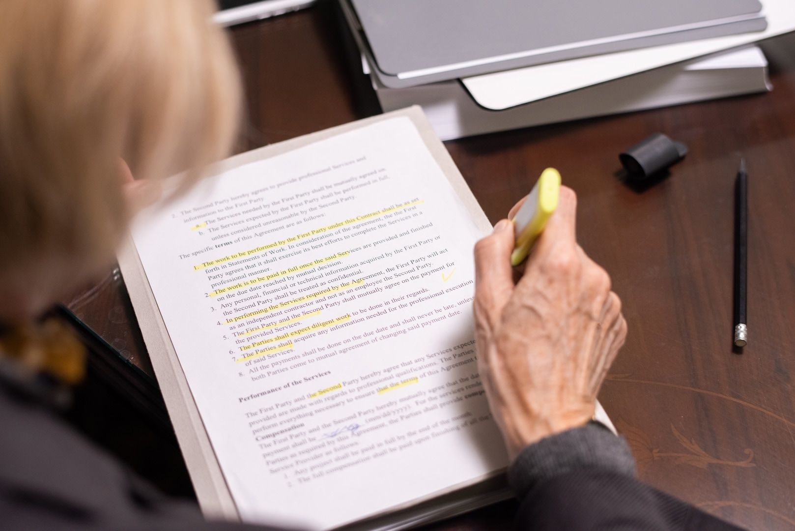 A hand highlighting lines on a printed page